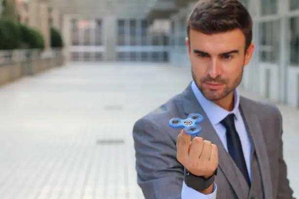 Photo of Fidget spinner entertaining elegant businessman