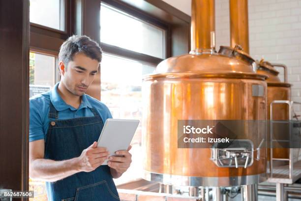 Bartender Using A Digital Tablet In Micro Brewery Stock Photo - Download Image Now - Brewery, Digital Tablet, Adult