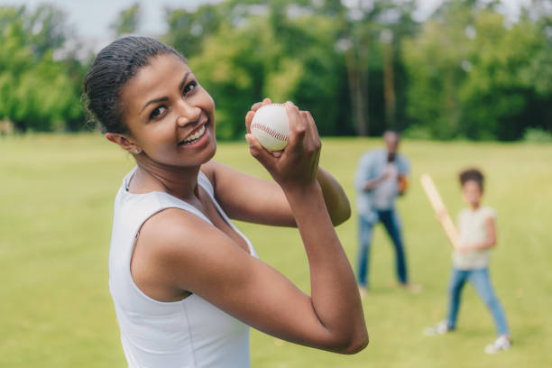 mulher afro-americana com uma bola de beisebol - blurred motion clothing mother offspring - fotografias e filmes do acervo