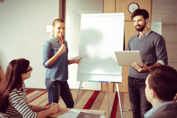 istock Smart young colleagues standing near the flipchart 862689264