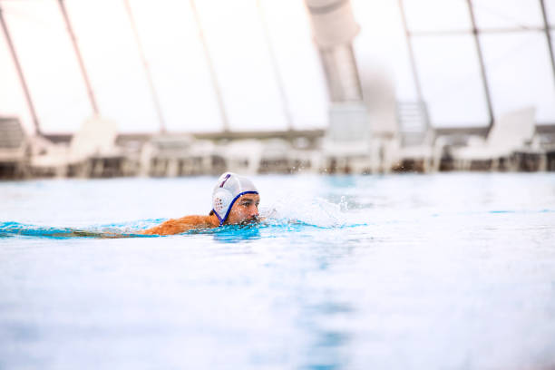 Water polo player in a swimming pool. Water polo player in a swimming pool. Man doing sport. water polo cap stock pictures, royalty-free photos & images