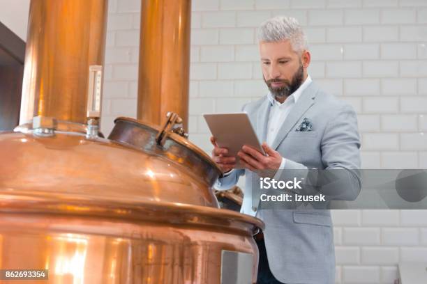 The Microbrewery Owner Using A Digital Tablet In His Micro Brewery Stock Photo - Download Image Now