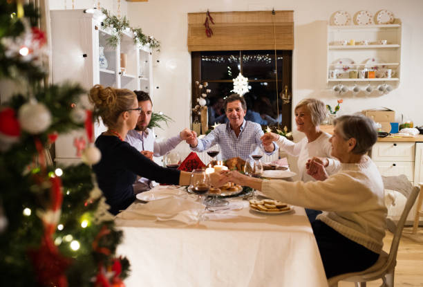 linda família grande christmat a celebrar juntos - family thanksgiving dinner praying - fotografias e filmes do acervo