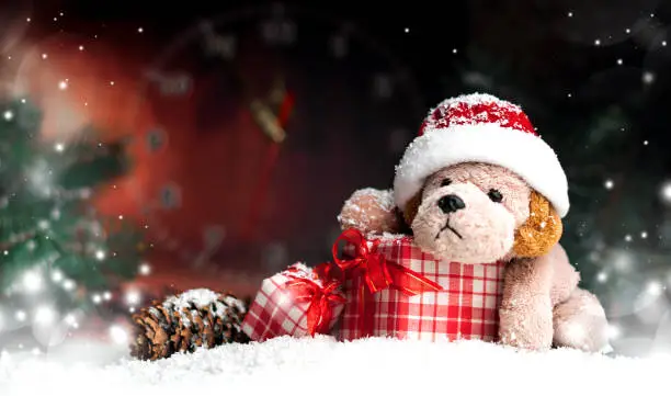 Decorative Christmas toy-dog, gifts in the snow on a dark background