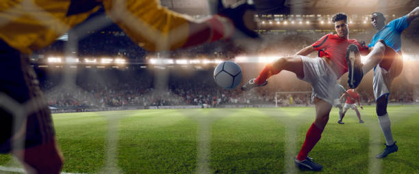 behind goal net view of footballer volleying to score goal - soccer player kicking soccer goalie imagens e fotografias de stock