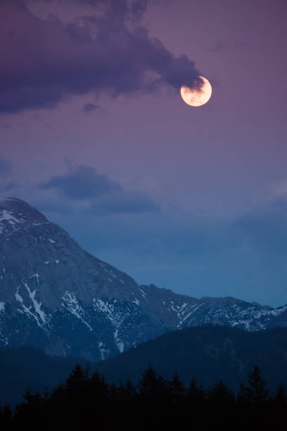landscape in the Alps with snow-capped mountain tops and the full moon, Berchtesgadener Land, Bavaria, Germany