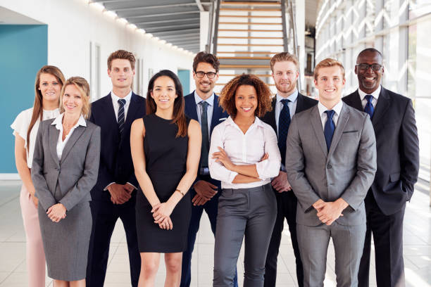 Office workers in a modern lobby, group portrait Office workers in a modern lobby, group portrait well dressed photos stock pictures, royalty-free photos & images