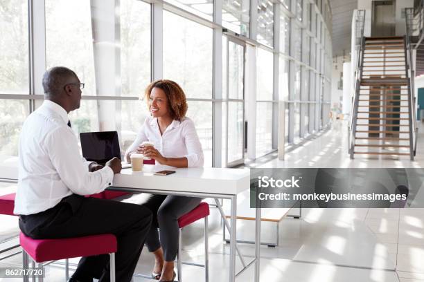 Businesswoman And Businessman At A Meeting Talking Stock Photo - Download Image Now