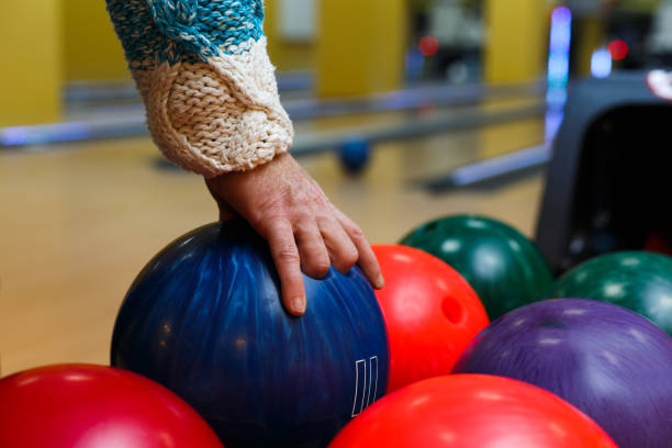 male hand taking ball from bowling machine - boliche de dez paus imagens e fotografias de stock