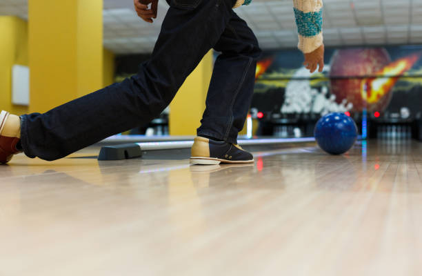 istock Man throw ball at bowling lane, cropped image 862718000