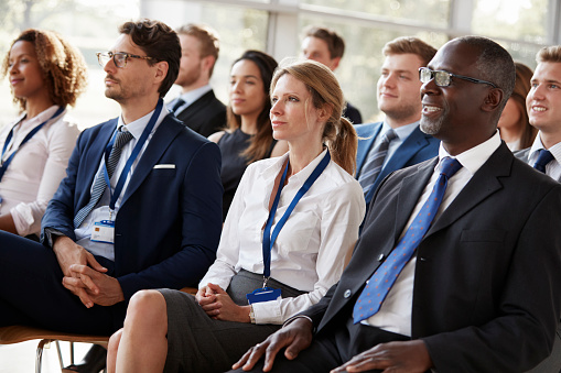 Business conference with unrecognizable audience. Shallow DOF, selective focus.