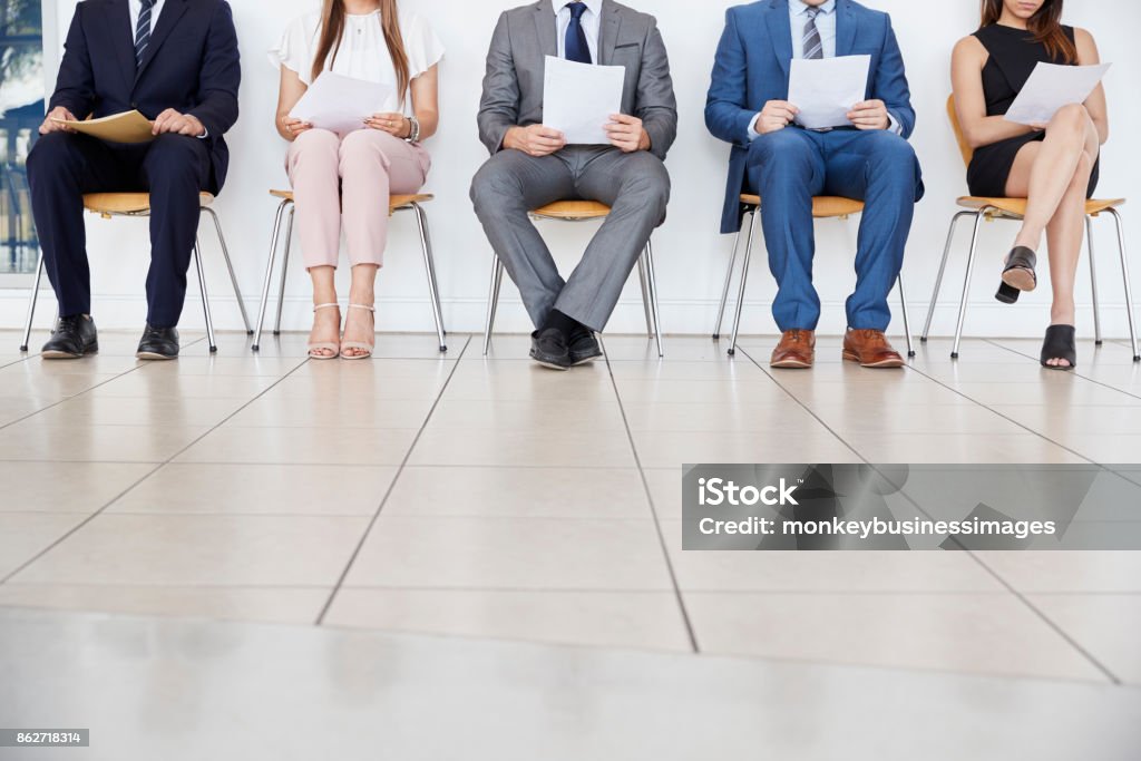 Cinco candidatos à espera para entrevistas de emprego, a vista frontal, a colheita - Foto de stock de Entrevista de Trabalho royalty-free