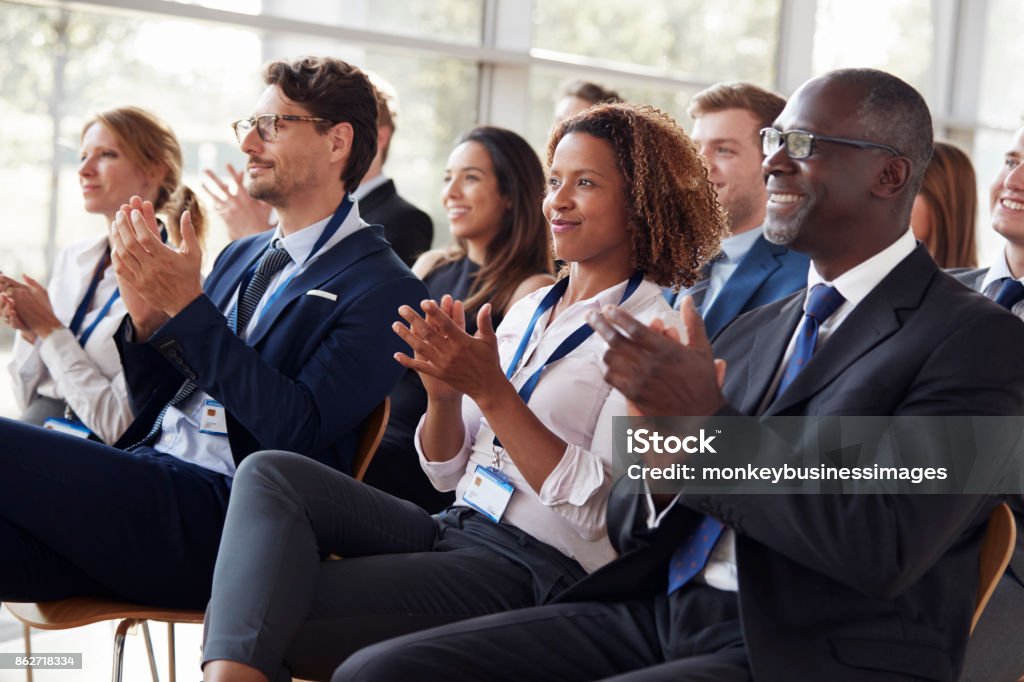 Sonriendo la audiencia aplaudiendo en un seminario de negocios - Foto de stock de Audiencia libre de derechos