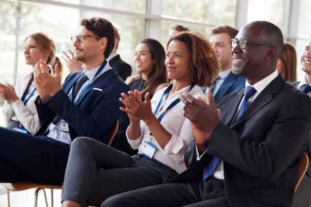 Smiling audience applauding at a business seminar Smiling audience applauding at a business seminar audience stock pictures, royalty-free photos & images