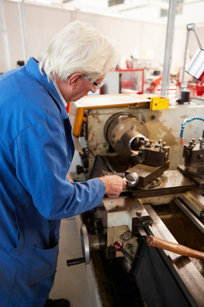 istock Senior engineer operating industrial machinery in a factory, vertical 862720860
