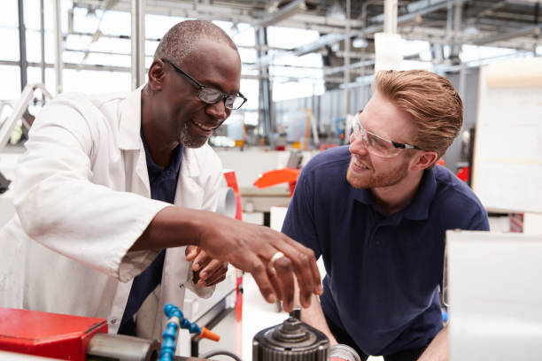 istock Engineer advising a male apprentice in a factory, close up 862721456