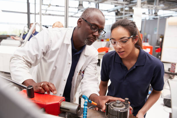 ingeniero equipo que muestra a un aprendiz de mujer, de cerca - aprendiz fotografías e imágenes de stock