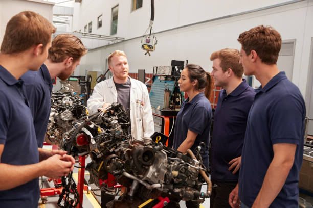 istock Apprentices studying car engines with a mechanic, close up 862721540