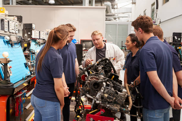 istock Car mechanic showing engines to apprentices 862721616