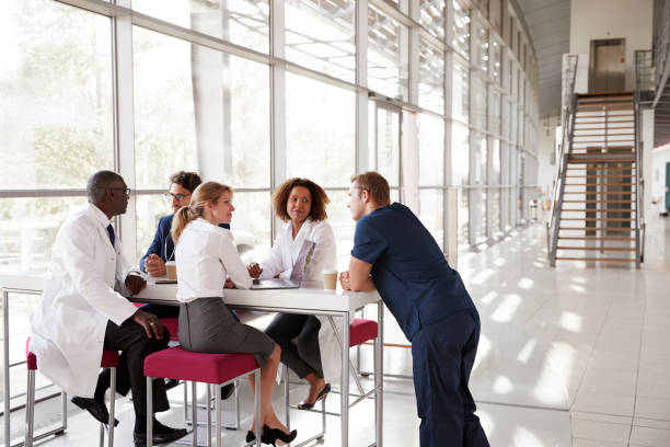 istock Five healthcare workers at a table in modern hospital lobby 862721730