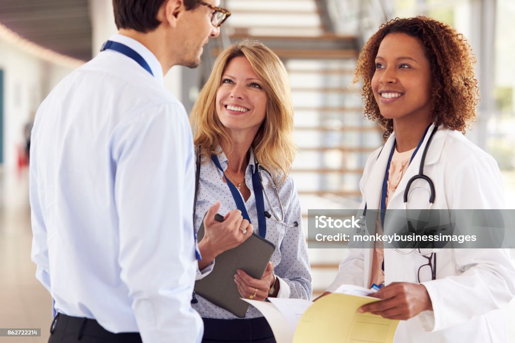 Three young male and female doctors in consultation Doctor Stock Photo