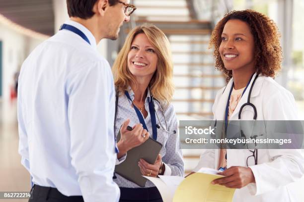 Three Young Male And Female Doctors In Consultation Stock Photo - Download Image Now