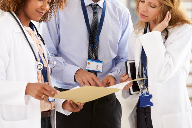 istock Three young male and female doctors consulting, mid section 862722250