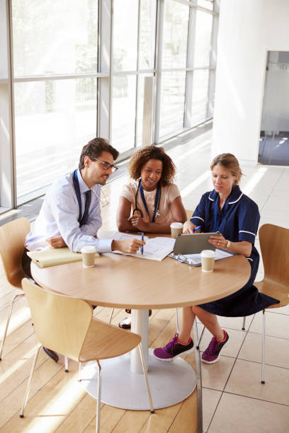 istock Three senior healthcare workers in a meeting, high angle 862724716