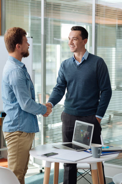 istock Delighted man shaking hands with his coworker 862731756