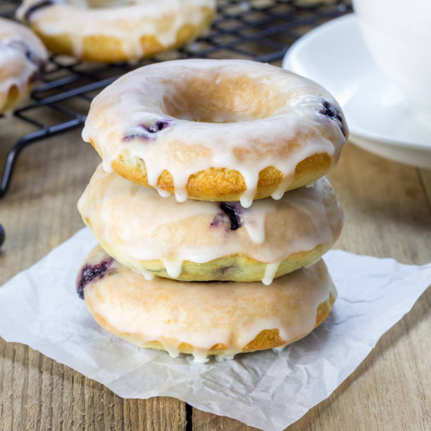 istock Freshly baked baked doughnuts with blueberries and lemon glaze, for breakfast, square format 862739084