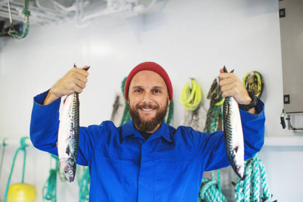Fisherman with fresh fish on the fishing boat deck