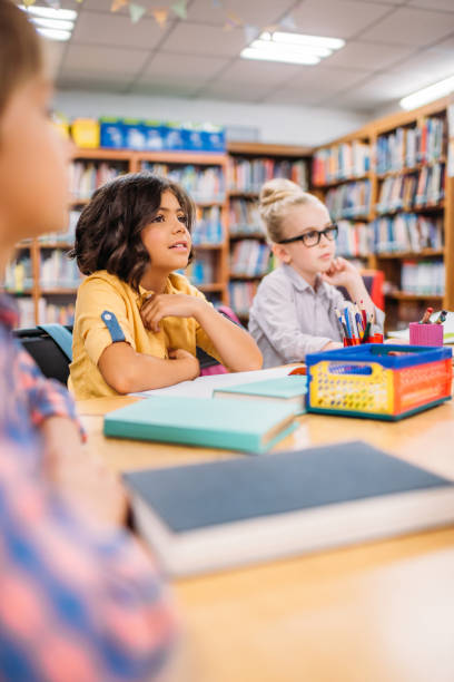 istock kids sitting at desk in library 862745512