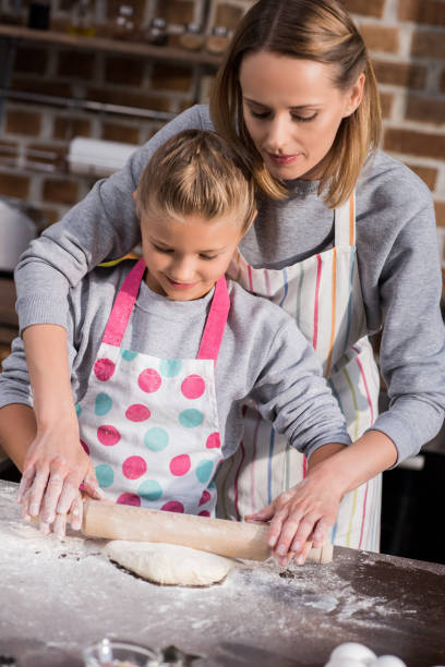 istock mother helping daughter with cooking 862745772