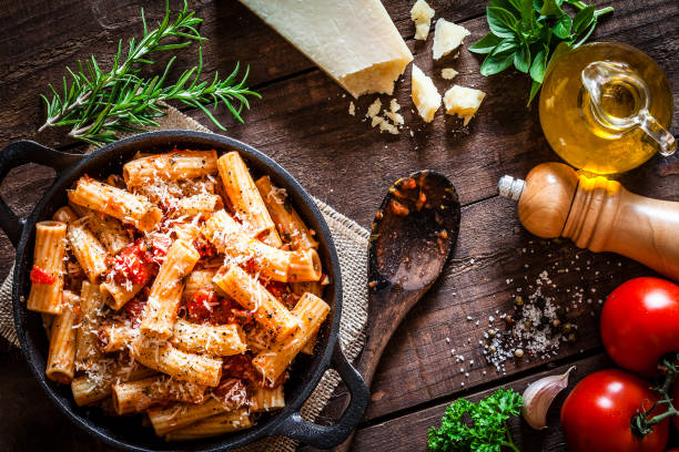 Pasta in a cast iron pan shot from above on rustic wooden table