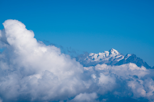 Kangchenjunga peak mount behind cloud cover landscape during blue sky day time,