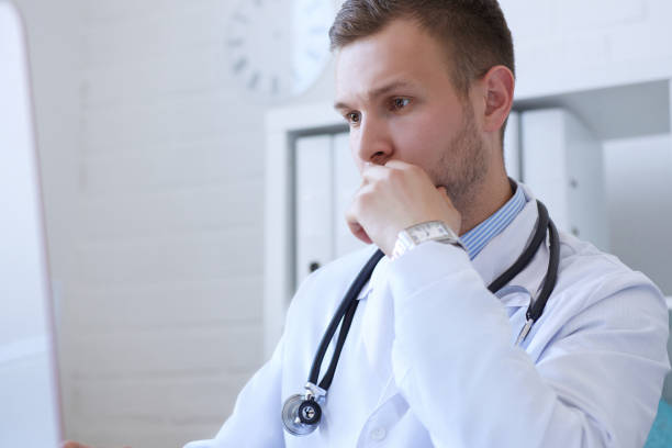 istock Young male doctor using computer on desk in clinic. 862767276