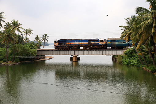 Kollam, India - October 15,2017 : A train passes through a railway bridge in Manroe Island in Kollam,Kerala, India.Manroe island is a tourist destination surrounded by lake and river