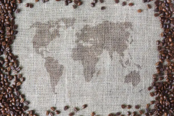 Photo of Burlap texture with coffee beans border and world map