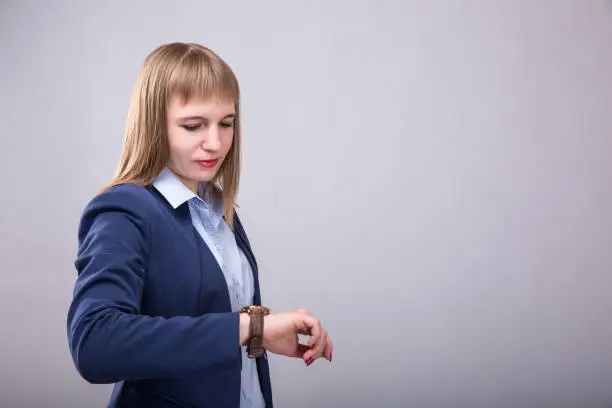 Photo of Time to do business. Thoughtful young woman in smart casual wear checking the time. Model look to the watch
