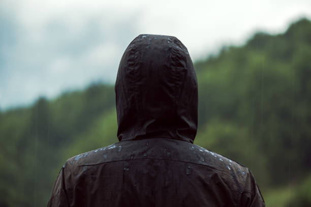 istock Rear view of hooded man standing in rain 862786778