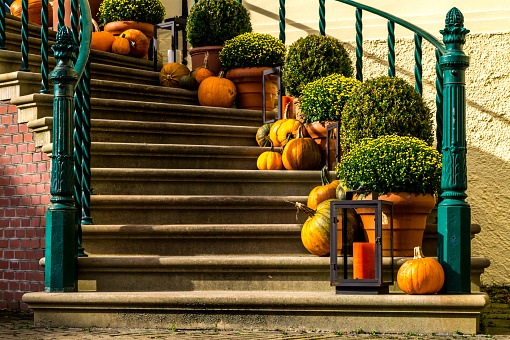 creativ autumn decoration on the stairs of a house. colorful flowers and pumpkins.