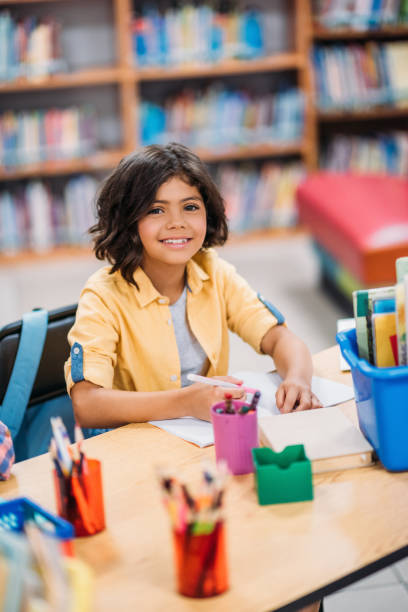 istock schoolgirl doing homework in library 862800398