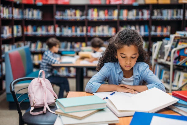istock schoolgirl reading book in library 862800510