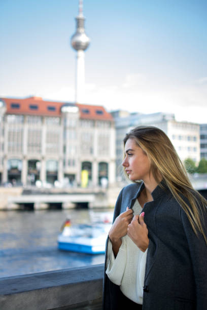 istock Young woman with coat enjoying view at river Spree in Berlin. 862804576