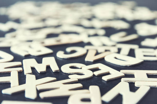 istock Close-up low angle view on multiple alphabet small wooden letters on dark gray texture 862808632