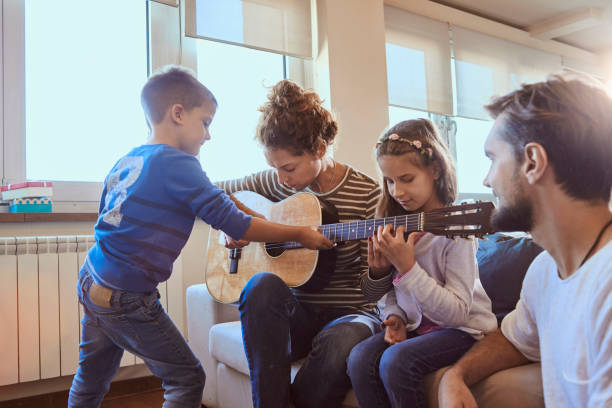 istock young mother playing guitar with her children 862931720