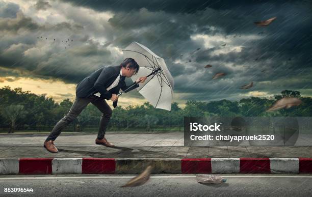 Businessman With White Umbrella Protecting Himself From The Storm Business Heavy Tasks And Problems Concept Stock Photo - Download Image Now