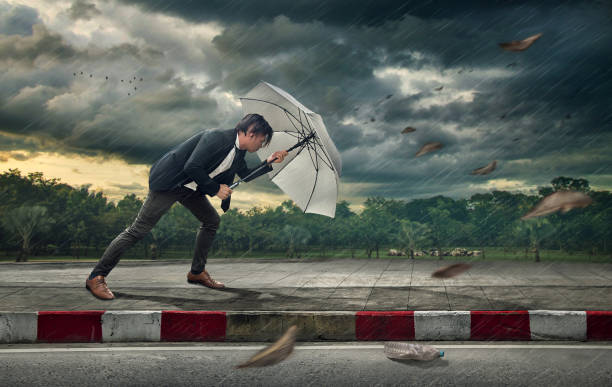 empresário com guarda-chuva branco a proteger-se da tempestade.  pesadas tarefas e problemas de conceito de negócio. - business struggle - fotografias e filmes do acervo