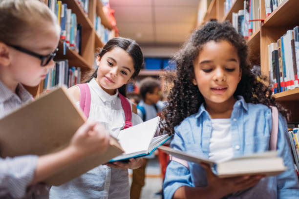 istock schoolgirls looking for books in library 863109858