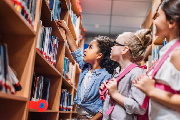 istock schoolgirls looking for books in library 863112054